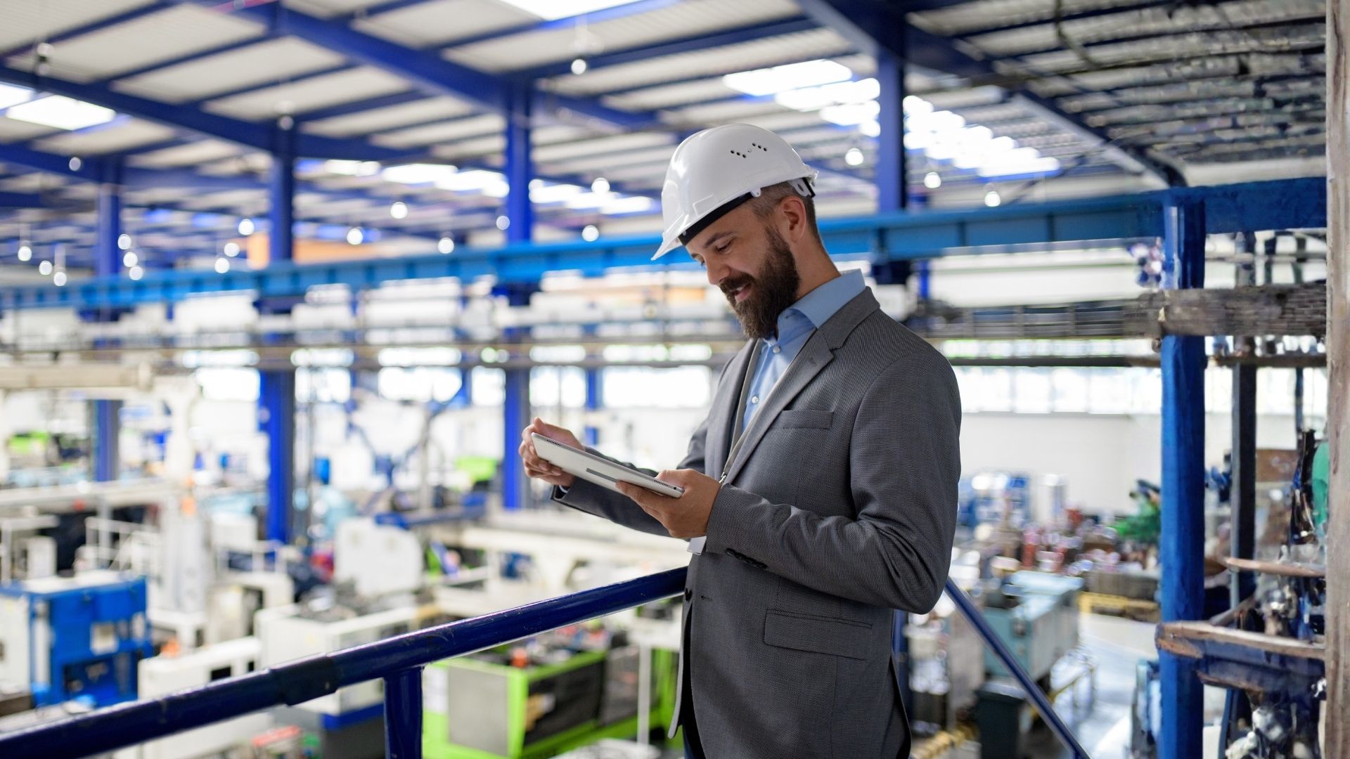 Responsabile Sicurezza che sta revisionando i dati su un tablet in una fabbrica moderna.